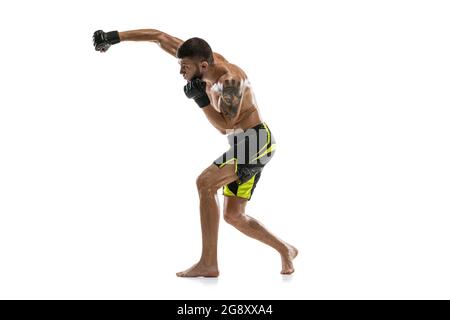 Boxer MMA professionnel mâle en mouvement isolé sur fond blanc de studio. Faire des combats musculaires d'athlète caucasien. Banque D'Images