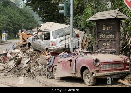 Bad Neuenahr Ahrweiler, Allemagne. 22 juillet 2021. Les véhicules détruits sont au bord de la route sur des tas de déchets encombrants. Sur une planche en bois, l'inscription 'Weinort Walporzheim' est visible. Le travail de nettoyage dans la zone inondée est en plein mouvement. De nombreuses voitures ont été lavées et détruites dans la région. Crédit : Bodo Marks/dpa/Alay Live News Banque D'Images