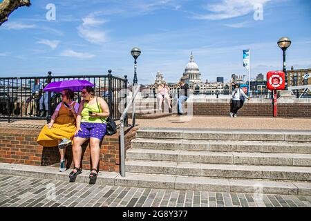 BANKSIDE LONDRES 23 juillet 2021 . Deux femmes qui se trouvent sous un parapluie sur bankside un autre jour chaud à Londres. Les prévisionnistes ont prédit que le temps chaud commencera à s'atténuer à partir de samedi avec une baisse des températures et des orages de crédit amer ghazzal / Alamy Live News Banque D'Images