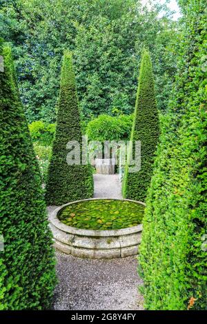 Pics de l'if tronqués et puits à Wollerton Old Hall Gardens, jardin, Wollerton, marché Drayton, Shropshire, Angleterre, Royaume-Uni Banque D'Images