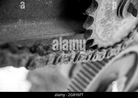 Détails rouillés des vieilles voitures abandonnées. Les pignons, les chaînes et les poulies rouillent dans l'ouverture. Pièces métalliques recouvertes de mousse de machines agricoles. Imag noir et blanc Banque D'Images