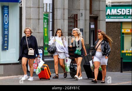 Dundee, Tayside, Écosse, Royaume-Uni. 23 juillet 2021. Météo au Royaume-Uni : une journée humide et couvert avec des sorts lumineux à travers le nord-est de l'Écosse avec des températures atteignant 21°C. Le confinement de Covid-19 s'est abaissé jusqu'au niveau zéro, les résidents locaux étant heureux de se rendre à l'extérieur pour s'amuser et profiter du temps d'été à Dundee. De jeunes femmes joyeuses et à la mode qui marchent ensemble des valises en roue dans le centre-ville. Crédit : Dundee Photographics/Alamy Live News Banque D'Images