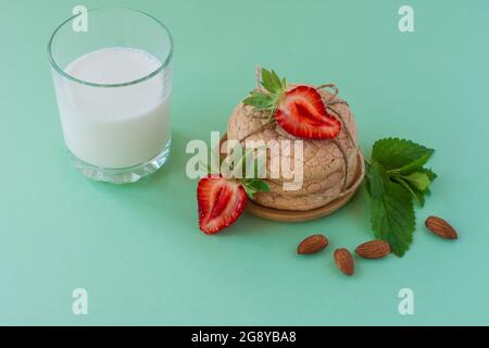 Biscuits aux amandes douces sur une table. Biscuit maison français. Cookies Lentien utiles de farine d'amande avec hfraisier et menthe sur fond vert. Sélectionnez Banque D'Images