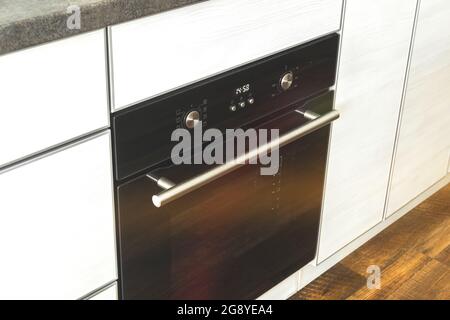 Four électrique fermé dans un décor moderne en bois cuisine intérieure Banque D'Images
