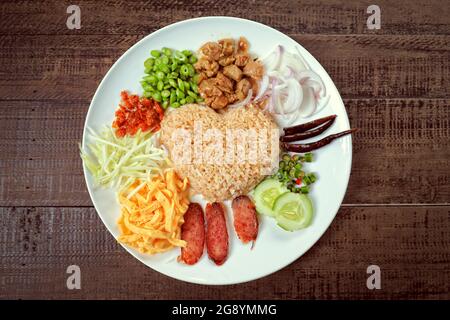 Populaire thaïlandais de la nourriture indigène, le riz frit avec la pâte de crevettes servir avec des légumes, des oeufs en tranches et des ingrédients épicés, la variété de légumes Banque D'Images