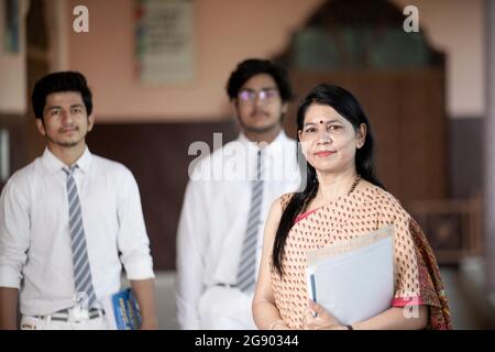 Professeur d'école indienne avec des élèves en arrière-plan Banque D'Images