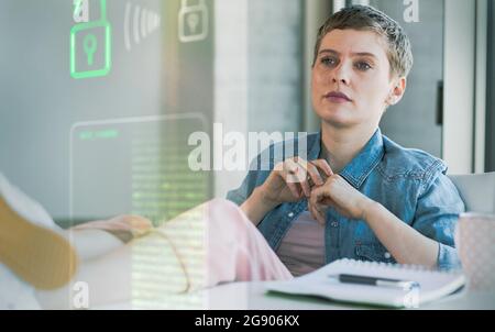 Femme d'affaires regardant le système de sécurité des données au bureau Banque D'Images