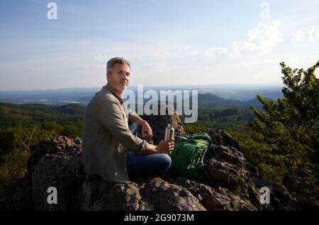 Randonneur mâle avec sac à dos et bouteille d'eau au sommet de la montagne Banque D'Images