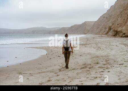 Homme marchant à la plage de point Reyes, Californie, États-Unis Banque D'Images