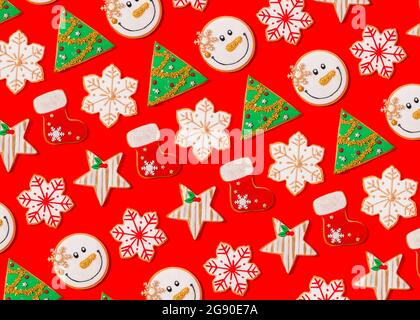 Motif de divers biscuits de Noël posés à plat sur fond rouge vif Banque D'Images