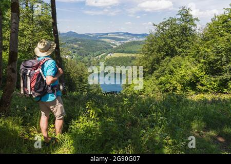 Randonneur expérimenté admirant le paysage entourant le lac Gemundener Maar Banque D'Images