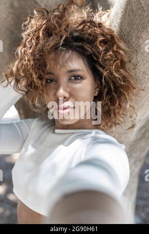 Jeune femme aux cheveux salissants prenant le selfie Banque D'Images