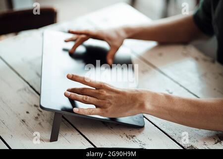 Homme d'affaires utilisant une tablette graphique sur une table de café Banque D'Images