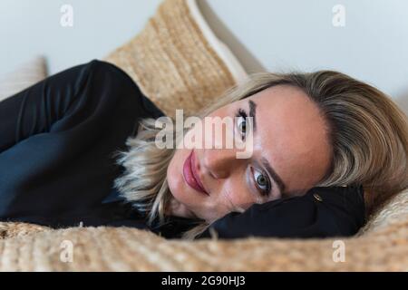 Belle femme d'affaires couchée sur le lit à la maison Banque D'Images