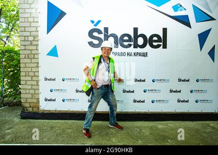 Un journaliste et photographe ukrainien pose la caméra contre le mur avec la marque locale de l'essence lors d'un voyage médiatique à la raffinerie de gaz de Shebelinka. Banque D'Images