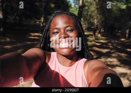 Bonne jeune femme prenant le selfie à la lumière du soleil Banque D'Images