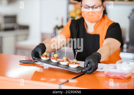 Chef féminin tenant un tableau de service au comptoir de la cafétéria Banque D'Images