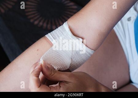 Le patient retire tout seul le pansement recouvrant la plaie de la ponction de l'aiguille médicale. Banque D'Images