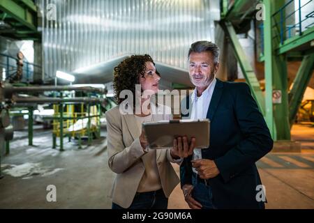 Femme professionnelle utilisant une tablette numérique avec un collègue de l'industrie Banque D'Images