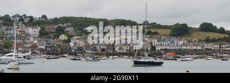 Scène côtière calme à Salcombe (Devon, Royaume-Uni) par un jour gris. Bateaux amarrés (yachts, voiliers, bateaux de croisière, bateau de sauvetage, dinghies) dans le port, avec buil Banque D'Images