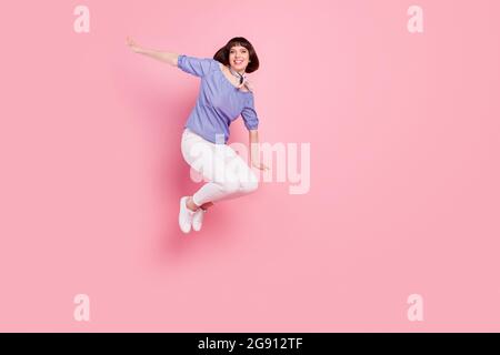 Pleine longueur de corps photo femme saut haut joueur souriant surjoyé isolé pastel couleur rose fond Banque D'Images