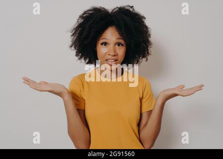 Confuse doute femme noire haussant avec les épaules, se sentant perplexe en regardant la caméra Banque D'Images