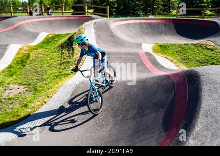 Calgary Alberta Canada, le 20 2021 juin : un jeune enfant fait le tour de la nouvelle piste de pompe BMX de South Glenmore Park sur son vélo lors d'une soirée d'été à Calgary Albert Banque D'Images