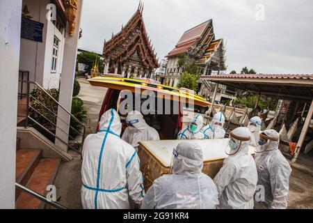 Nonthaburi, Thaïlande. 23 juillet 2021. Les membres du personnel de la fondation Siam Nonthaburi portent un cercueil d'une victime de COVID-19 à un crématorium au temple de Sao Thong Hin à Nonthaburi.au milieu de la mort des victimes et des suspects de COVID-19, la fondation Siam Nonthaburi porte gratuitement les victimes de COVID-19 à un cremate. En juillet, ils avaient incinéré plus de 240 morts dans les temples autour de Nonthaburi. (Photo de Varuth Pongsaponwatt/SOPA Images/Sipa USA) crédit: SIPA USA/Alay Live News Banque D'Images