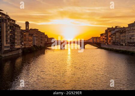 Pont historique silhoueté contre le ciel doré au-dessus de la rivière Arno à Florence, Toscane, Italie Banque D'Images