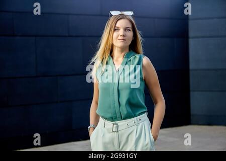 De jeunes femmes élancées se trouvent près du centre d'affaires. Banque D'Images