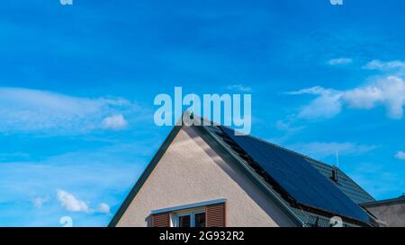 Panneaux solaires sur le toit d'une maison générant de l'énergie électrique propre par la puissance de la lumière du soleil fournissant l'énergie pour le bâtiment Banque D'Images