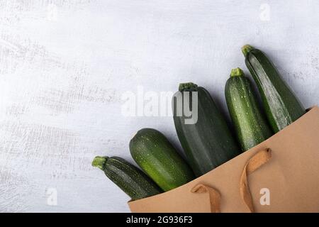 Courgette biologique dans un sac de papier brun. Concept de recyclage des emballages. Pas de déchets plastiques. Espace pour le texte. Banque D'Images