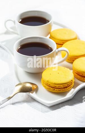 Macarons et tasse de café sur table en bois blanc. Banque D'Images