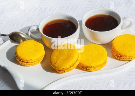 Macarons et tasse de café sur table en bois blanc. Banque D'Images