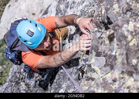 garçon grimpant dans les pyrénées avec sac à dos et casque Banque D'Images