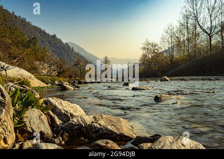 rivière traversant la vallée de montagne brumeuse couverte de forêts denses et ciel bleu à l'aube image est prise au shergaon arunachal pradesh inde. Banque D'Images