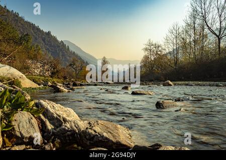 rivière traversant la vallée de montagne brumeuse couverte de forêts denses et ciel bleu à l'aube image est prise au shergaon arunachal pradesh inde. Banque D'Images