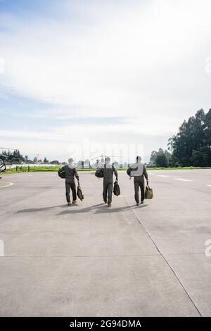 trois militaires marchant sur une piste vers les hélicoptères Banque D'Images