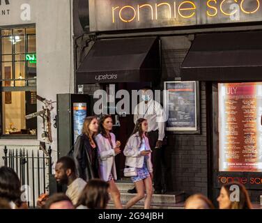 Garde de sécurité avec masque et personnes marchant dans la rue à Soho, Londres, Royaume-Uni. Banque D'Images