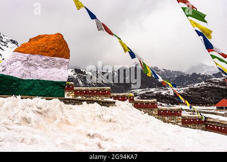 la pierre tricolore indienne avec le saint drapeau bouddhiste au monument commémoratif de guerre et les montagnes à chapeau de neige en arrière-plan est prise au mémorial de guerre de jaswant singh, bumla Banque D'Images