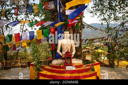 bouddha assis dans la posture de méditation avec des drapeaux religieux au jour de l'angle plat au monastère d'itanagar arunachal pradesh inde. Banque D'Images