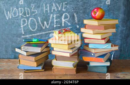 Pile de livres et de légende sur le tableau noir des mots ont le pouvoir, de retour à l'école, la lecture d'éducation, le concept d'apprentissage Banque D'Images