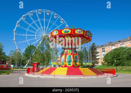 VELIKIE LUKI, RUSSIE - 04 JUILLET 2021 : carrousel coloré sur le fond de la grande roue dans le parc de la ville de la culture et des loisirs au soleil Banque D'Images