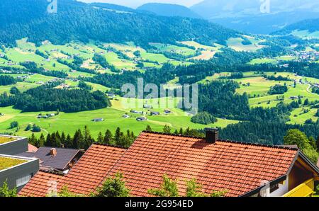 Décor de maisons rustiques dans la vallée verdoyante alpine, Autriche, Europe. Toits dans village traditionnel sur fond de forêt de montagne. Paysage rural te Banque D'Images