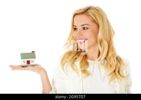 Jeune femme d'affaires montrant des modèles de maison sur sa main. Banque D'Images