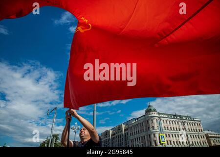 Moscou, Russie. 24 juillet 2021 UN homme porte le drapeau de l'URSS sur la rue Tverskaya dans le centre de Moscou, en Russie Banque D'Images