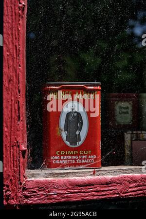Une vitrine de magasin de campagne antique, peinte en rouge, date du milieu du XIXe siècle. Ces magasins de campagne ont joué un rôle vital dans les collectivités, offrant des marchandises et des services postaux. Banque D'Images