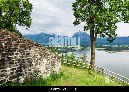 Vue depuis les ruines du château au-dessus du lac Hopfen jusqu'aux montagnes des Alpes d'Ammergau avec le château de Neuschwanstein, Allgäu, Bavière, Allemagne Banque D'Images