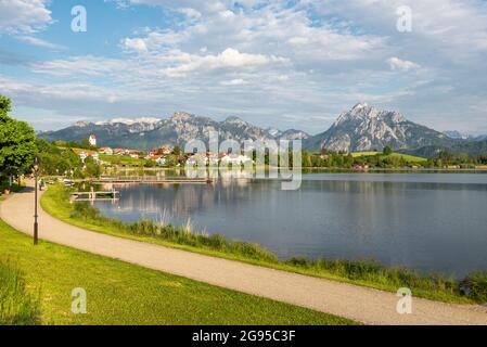 Le lac Hopfen, le village de Hopfen et les montagnes des Alpes d'Ammergau brillent au soleil de l'après-midi, Allgäu, Bavière, Allemagne Banque D'Images