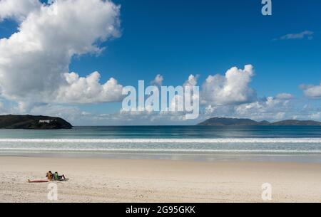 Couple profitant d'une plage tropicale désertique assis sur le sable à Cabo Frio Brésil Banque D'Images